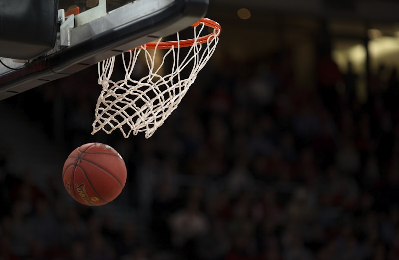 NBA篮球比赛精彩瞬间，球员飞身扣篮，球场灯光璀璨，观众席热情欢呼，展现顶级篮球竞技魅力